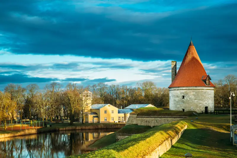 Zabytkowa baszta z czerwonym dachem nad wodą w Kuressaare